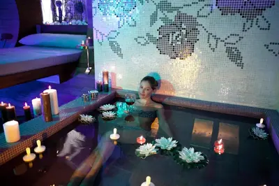 a woman in a swimming pool with candles and flowers at Taba Luxury Suites and Hotel in Istanbul