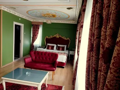 a bedroom with a red couch and a bed at Hotel Anibal in Gebze
