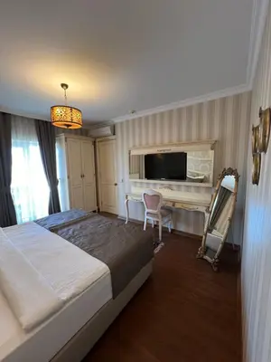 a bedroom with a bed and a desk and a television at Muyan Suites in Istanbul