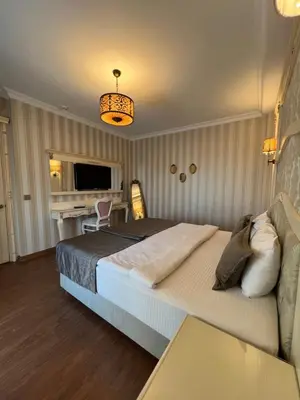 a bedroom with a large bed and a living room at Muyan Suites in Istanbul