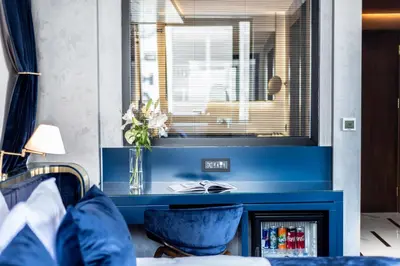 a bedroom with blue walls and a window with blue chairs at The Wings Hotels Karakoy in Istanbul