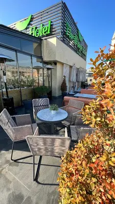 a patio with a table and chairs in front of a hotel at The Wings Hotels Karakoy in Istanbul