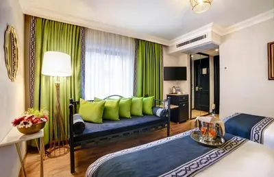 a hotel room with two beds and a couch at Hotel Ephesus Istanbul in Istanbul
