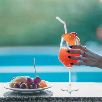 a person holding a drink next to a plate of fruit at Alfa Suites & SPA in Sapanca