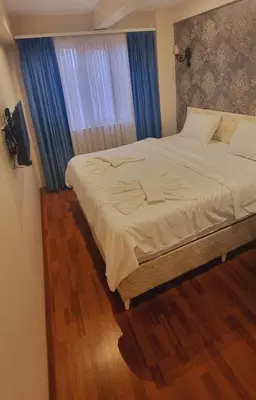 a bedroom with a large bed with blue curtains at By Historial Hotel Due in Istanbul