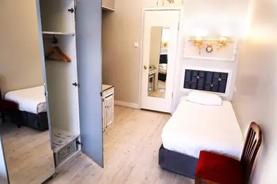 a small room with a bed and a mirror at Bakirkoy Tashan Business & Airport Hotel in Istanbul