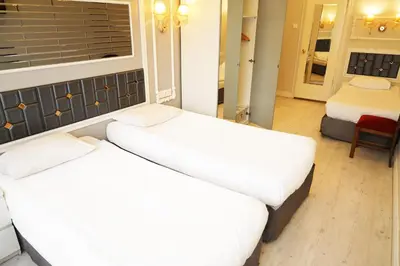 two beds in a room with a window at Bakirkoy Tashan Business & Airport Hotel in Istanbul