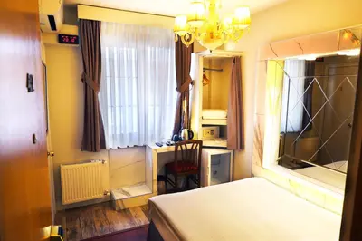 a bedroom with a bed and a window and a chandelier at Bakirkoy Tashan Business & Airport Hotel in Istanbul