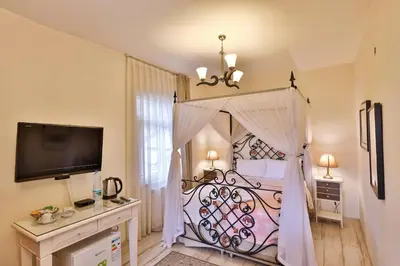 a bedroom with a large bed with a canopy at Park Mandalin Hotel - Adult only in Agva