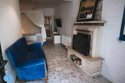 a living room with a blue couch and a fireplace at Park Mandalin Hotel - Adult only in Agva