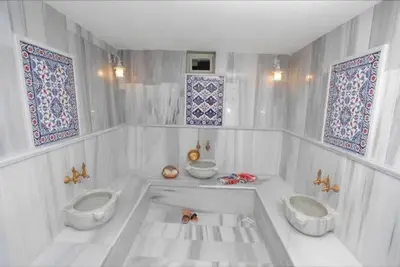 a white bathroom with two toilets and windows at HHK Hotel in Istanbul