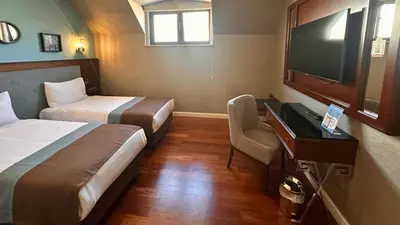 a hotel room with two beds and a desk and a television at Grand Durmaz Hotel in Istanbul