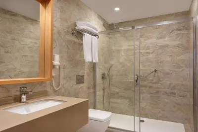 a bathroom with a shower and a toilet and a sink at TRYP by Wyndham Izmit in Kocaeli