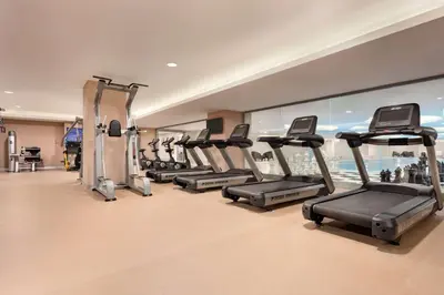a gym with a row of treadmills at TRYP by Wyndham Izmit in Kocaeli