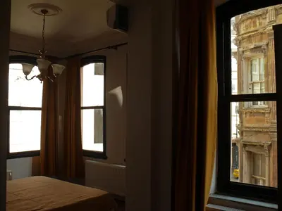 a bedroom with two windows and a bed in front thereof at Budak Residence in Istanbul