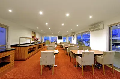 a dining room with tables and chairs and windows at Kardes Hotel in Bursa