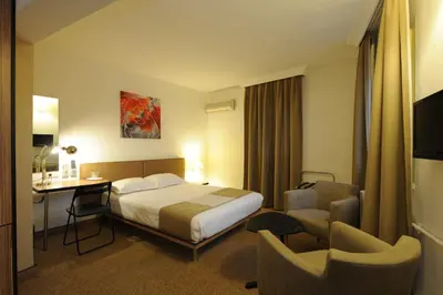 a hotel room with a bed and a desk and chairs at Kardes Hotel in Bursa