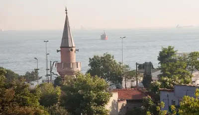 a church steeple with a ship in the water at Sultans Hotel in Istanbul