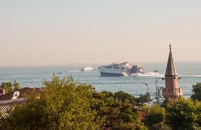 a boat in the water with a cruise ship at Sultans Hotel in Istanbul