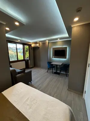 a hotel room with a bed and a table and chairs at Sahrakent Otel Ataşehir in Istanbul