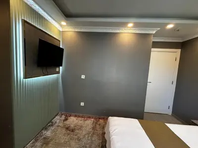 a bedroom with a bed and a tv on a wall at Sahrakent Otel Ataşehir in Istanbul