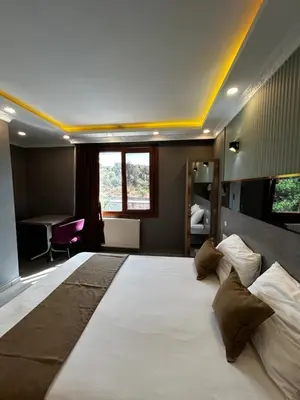 a large white bed in a room with a desk at Sahrakent Otel Ataşehir in Istanbul