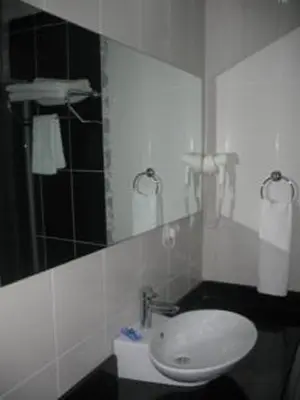 a bathroom with a white sink and a mirror at Shilla Hotel in Velimeşe