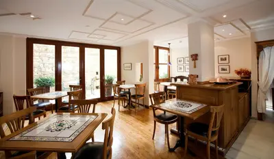 a restaurant with wooden tables and chairs and windows at Hotel Sari Konak in Istanbul