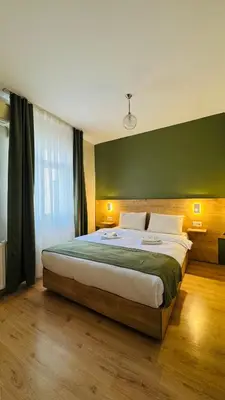 a bedroom with a large bed with a green wall at Sultan Hostel & Guesthouse in Istanbul