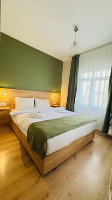 a large bed in a bedroom with a green wall at Sultan Hostel & Guesthouse in Istanbul