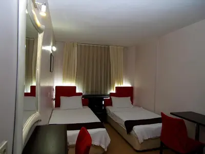 a hotel room with two beds and red chairs at Hotel Timya in Istanbul