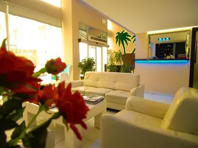 a living room with white couches and a table and flowers at Hotel Timya in Istanbul