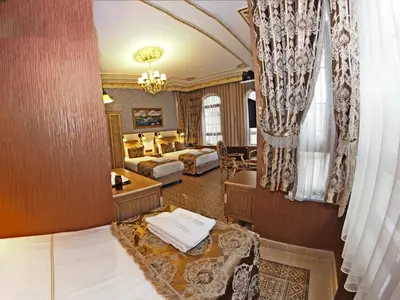 a hotel room with two beds and a sitting area at Glamour Classic Hotel Istanbul Sirkeci in Istanbul