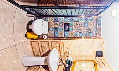 a bathroom with a toilet and tiles on the wall at Glamour Classic Hotel Istanbul Sirkeci in Istanbul