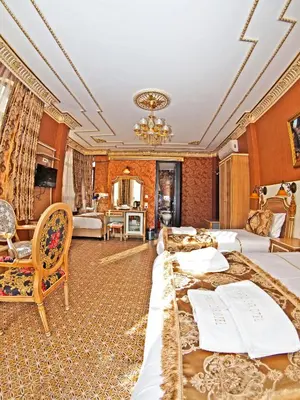 a hotel room with two beds and a living room at Glamour Classic Hotel Istanbul Sirkeci in Istanbul