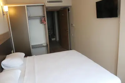 a small bedroom with a bed and a television at Longoz Hotel in Igneada