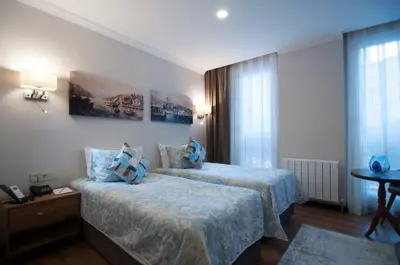 a hotel room with two beds and a table at Nomade Hotel Exclusive in Istanbul