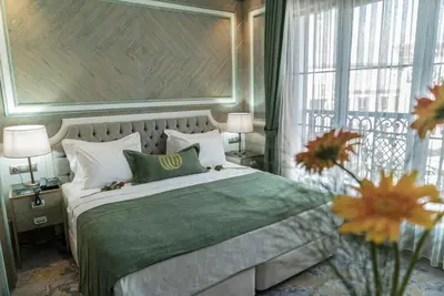 a bedroom with a large bed with a green blanket at Mirart Hotel Boutique & SPA Yalova in Yalova