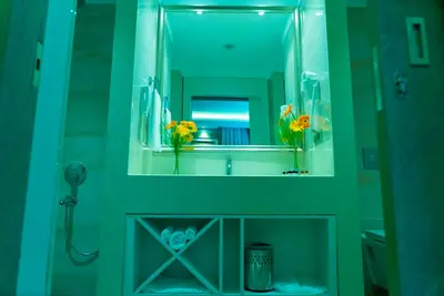 a bathroom with a mirror and a sink with flowers at Mirart Hotel Boutique & SPA Yalova in Yalova