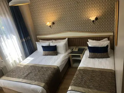a hotel room with two beds and a window at Mevlana Hotel in Istanbul