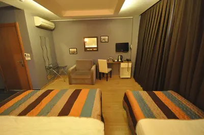 a hotel room with two beds and a chair at Retropera Hotel in Istanbul