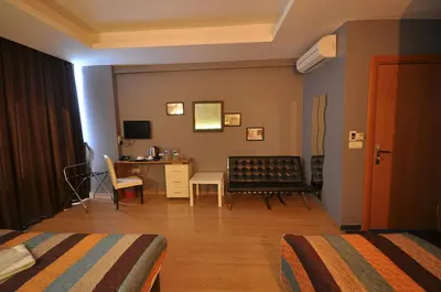a hotel room with two beds and a desk at Retropera Hotel in Istanbul