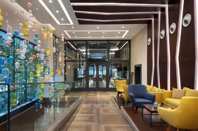 a lobby with a christmas tree and yellow chairs at Sheraton Istanbul City Center in Istanbul