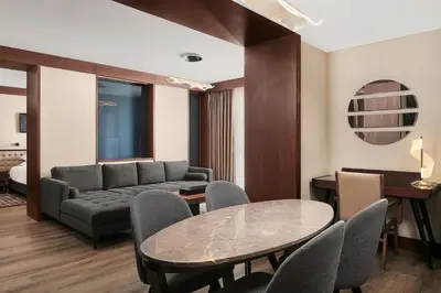 a living room with a couch and a table and chairs at Sheraton Istanbul City Center in Istanbul