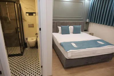 a bedroom with a bed with blue and white pillows at Florya House Hotel in Istanbul