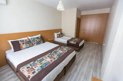 a bedroom with two beds and a cabinet at Formback Thermal Suit & Apart in Bursa