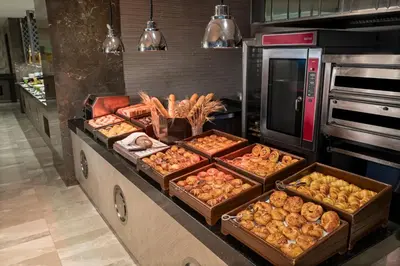 a kitchen with several trays of food on a counter at Windsor Hotel & Convention Center Istanbul in Istanbul