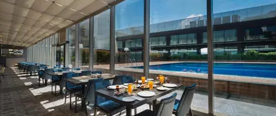 a restaurant with tables and chairs and a swimming pool at Windsor Hotel & Convention Center Istanbul in Istanbul