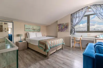 a bedroom with a bed and a desk and a window at Elanaz Hotel in Istanbul