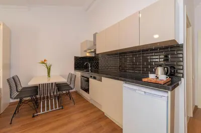 a kitchen with white cabinets and a table with chairs at Joy Suites in Istanbul